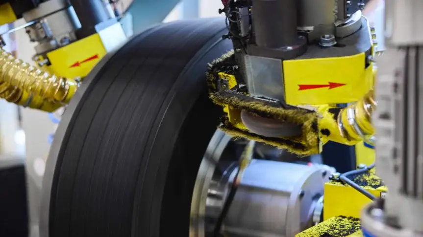 Tiaxon Maschine bei der präzisen Bearbeitung eines Nutzfahrzeugreifens im Produktionsprozess für langlebige und leistungsstarke Reifenlösungen